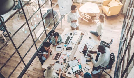 corporate team collaborating working at table overhead view web slider image    