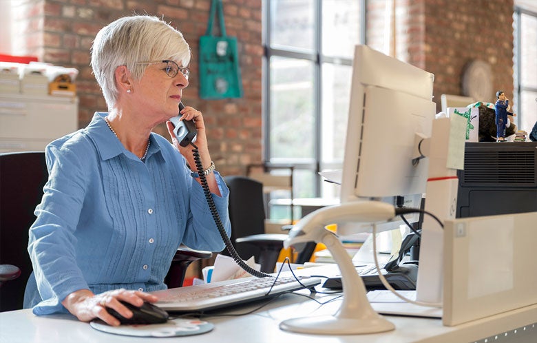 Librarian on the phone while looking something up on the computer