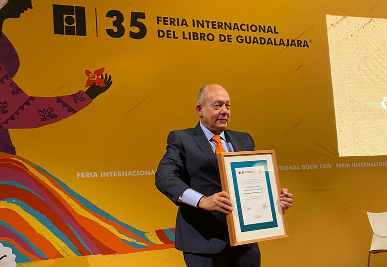Oscar Saavedra holding award
