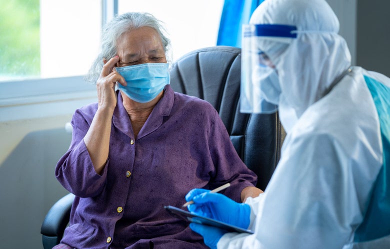 Doctor checking an elderly woman patient wearing a face mask in hospital