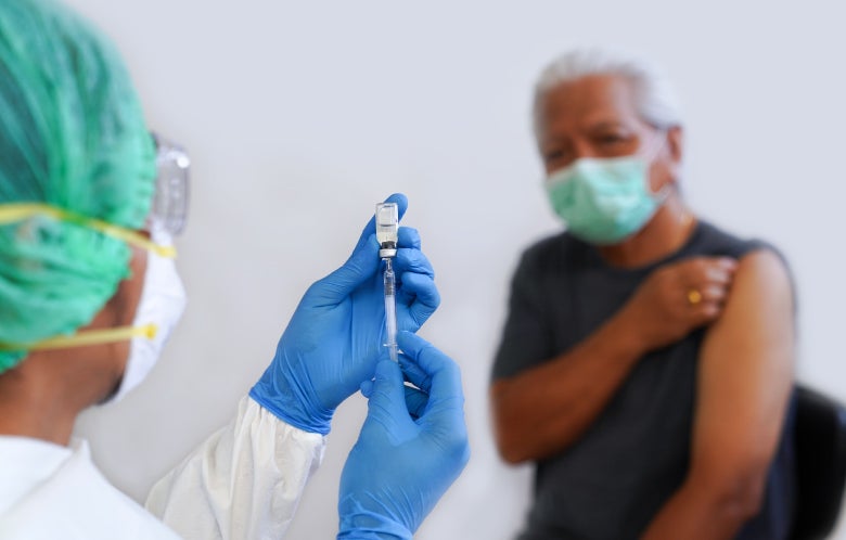 Close-Up Of Doctor Preparing Syringe For Patient