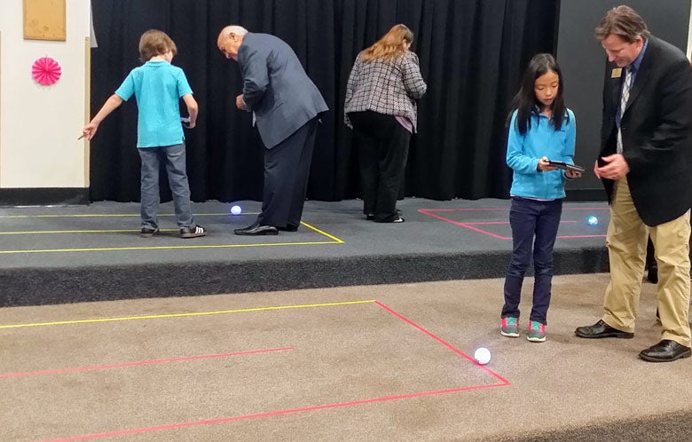 students showing teachers their projects at a science fair