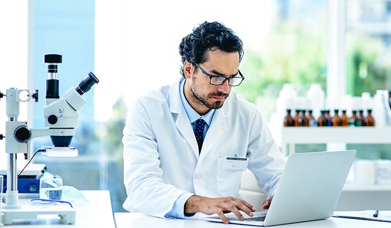 scientist working on a laptop in a lab