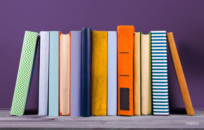 colorful books on a shelf with a purple background