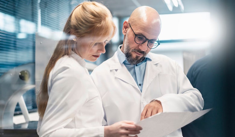 two lab technicians looking at a plan