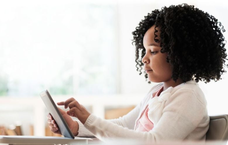 Young girl interacting with her tablet.