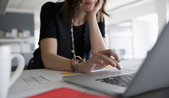 woman scrolling on a laptop